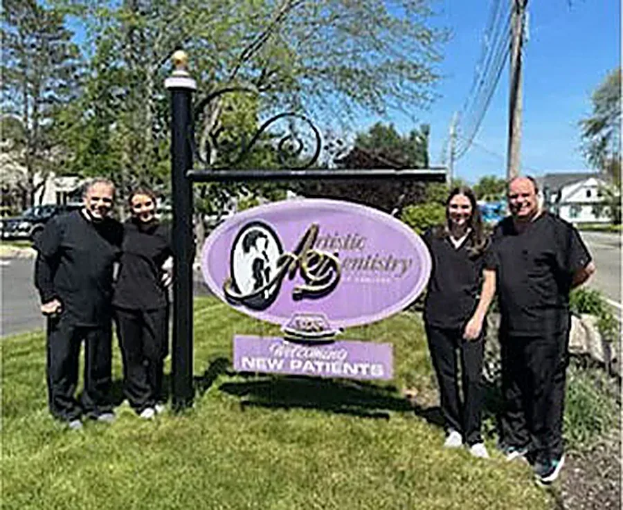 Our doctors outside the Artistic Dentistry of Hanover sign